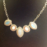 Gold tone bib style necklace in blue and white