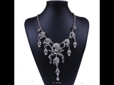 Skull and pistol rhinestone necklace.